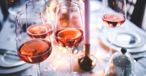 glasses of rose on a table set for a meal