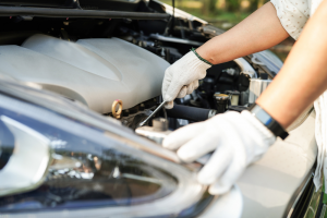 person in white gloves working on a car engine