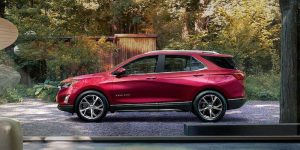 2021 Chevrolet Equinox in red parked in a wooded area