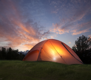 a tent at sunset, with light shining through the tent