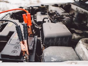 A car's engine with jumper cables attached to the battery
