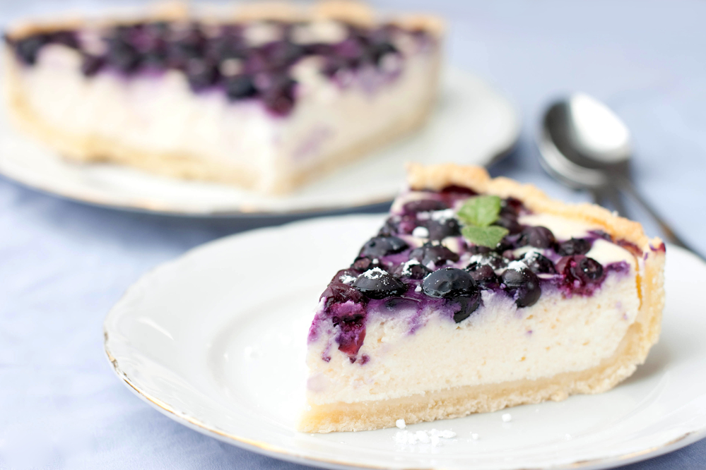 a slice of blueberry cheesecake on a white plate