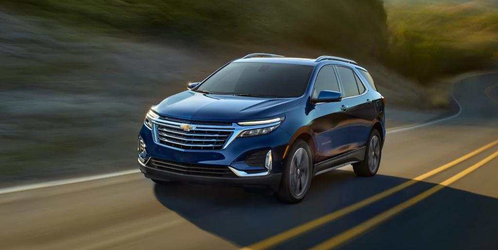 A blue 2022 Chevrolet Equinox driving down a road.
