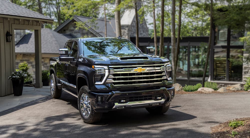 A black 2024 Chevy Silverado 2500 HD High Country is shown from the front at an angle.
