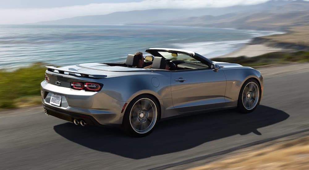 A silver 2021 Chevy Camaro Convertible is shown from the rear at an angle.