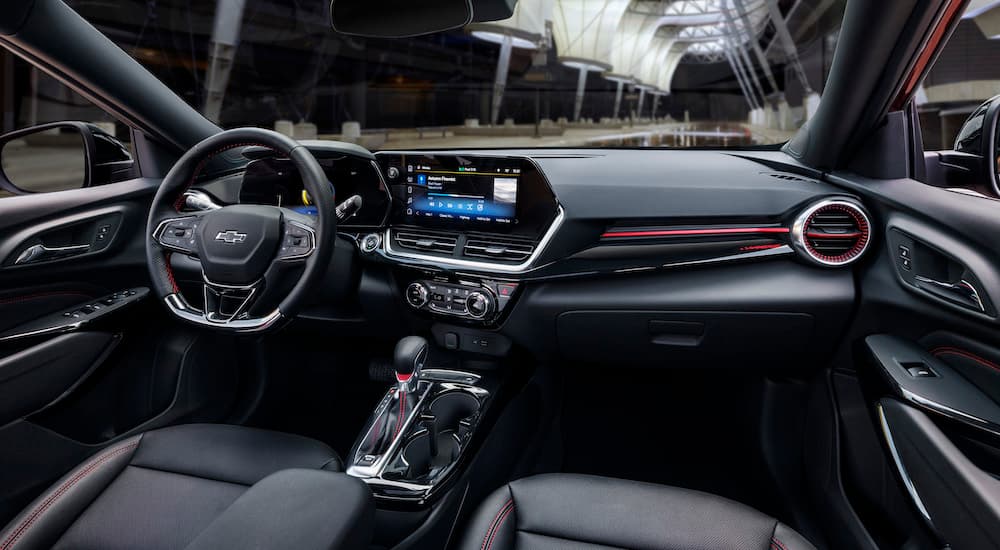 The black and red interior of a 2024 Chevy Trax RS at a Chevy dealer near New Iberia.