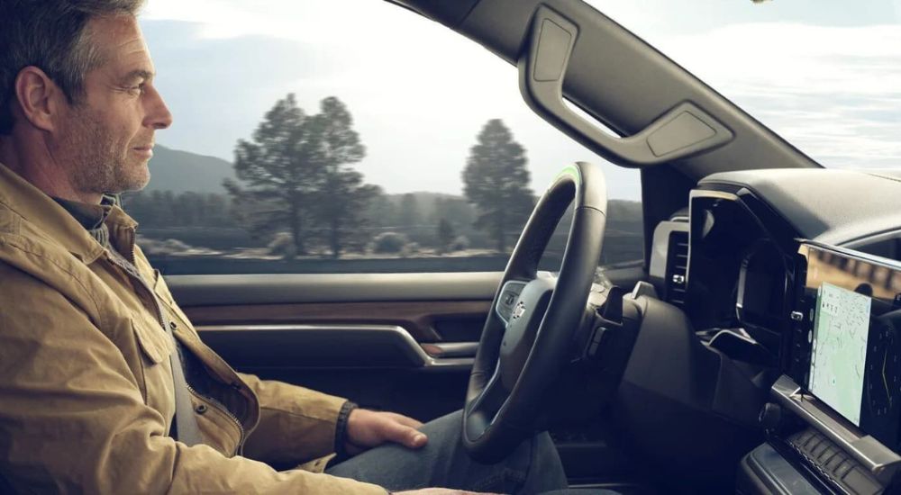 A man sitting in the driver seat of a 2024 Chevy Silverado 1500.