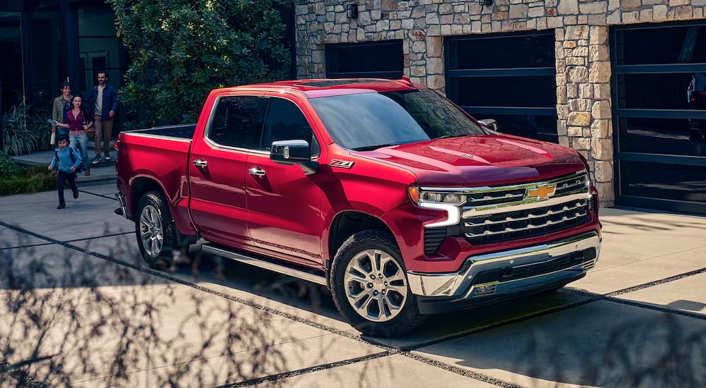 A red 2024 Chevy Silverado 1500 LTZ is parked in a driveway after leaving a Chevy dealer near Breaux Bridge.