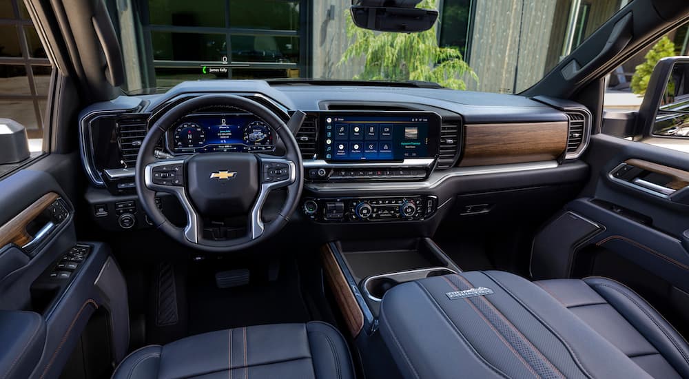 The black interior of a 2024 Chevy Silverado 2500 HD High Country is shown from the driver's seat.
