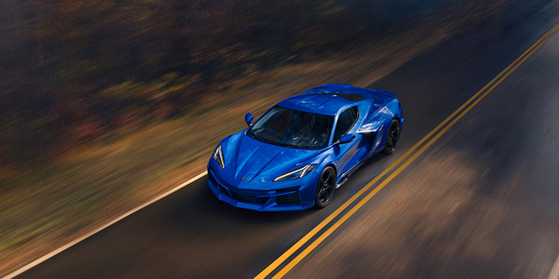 Top shot of a blue 2025 Corvette E-Ray driving on a road